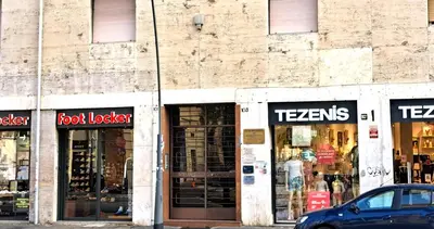 a store front with a car parked in front at San Giovanni Metro Flat in Rome