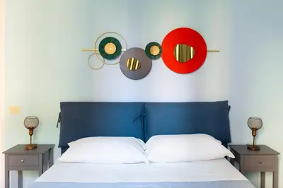 a bed with a blue headboard with two nightstands and two records at Rétro Chic Circo Massimo in Rome