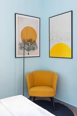a bedroom with a yellow chair and two pictures at Rétro Chic Circo Massimo in Rome