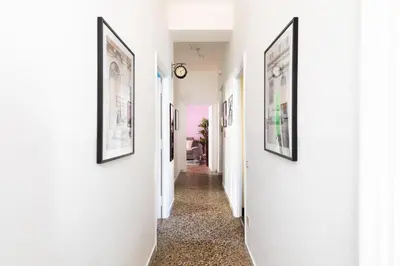 a hallway with white walls and pictures on the walls at Rétro Chic Circo Massimo in Rome