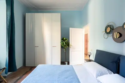 a bedroom with blue walls and a white bed at Rétro Chic Circo Massimo in Rome