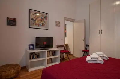 a bedroom with a bed and a tv and a book shelf at Cozy apartment in Esquilino in Rome
