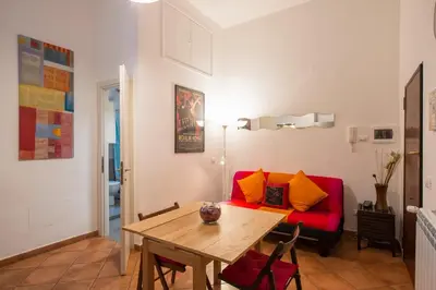 a living room with a red couch and a wooden table at Cozy apartment in Esquilino in Rome