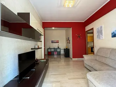 a living room with a couch and red walls at Hidden Gem in Magliana in Rome