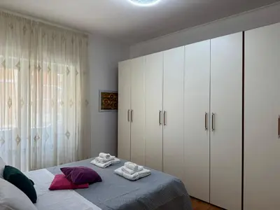 a bedroom with white cabinets and a bed with towels on it at Hidden Gem in Magliana in Rome