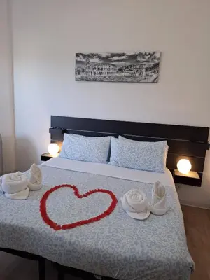 a heart on a bed with towels and shoes on it at Roma Trastevere Holiday in Rome