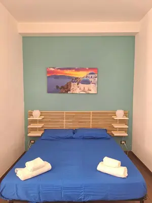 a bedroom with a blue bed with two towels on it at Roma Trastevere Holiday in Rome