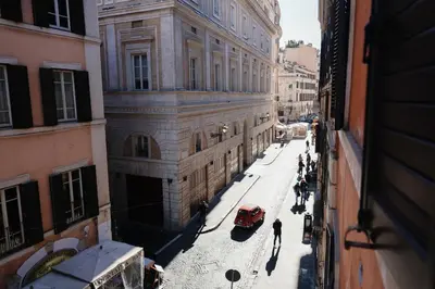 a view of a street with a red car in front of a building at loft a Castel S Angelo A e B in Rome