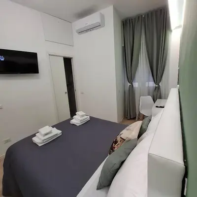 a bedroom with two beds and a tv on the wall at Bemy in Rome