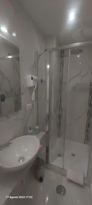 a white bathroom with a shower and a sink at Bemy in Rome