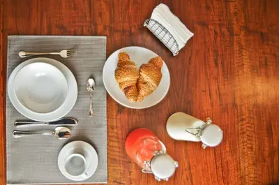 a table with a plate of croissants and a cup of coffee at B&B Carini 58 in Rome
