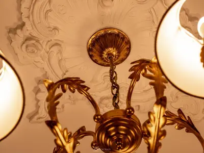 a gold chandelier hanging from a ceiling at Alla Basilica Rooms in Rome