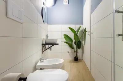 a white bathroom with a toilet and a sink at Aureum Angelicum in Rome