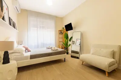 a bedroom with a bed and a chair and a mirror at Aureum Angelicum in Rome