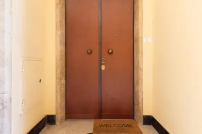 a door in a room with a welcome sign on the floor at Aureum Angelicum in Rome