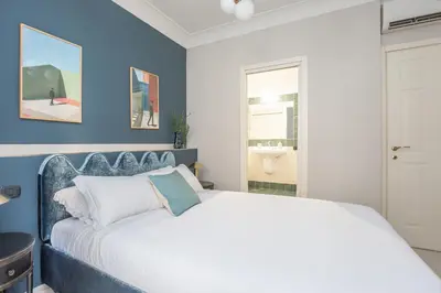 a bedroom with a white bed and blue walls at Daplace - Palazzina Cosima in Rome