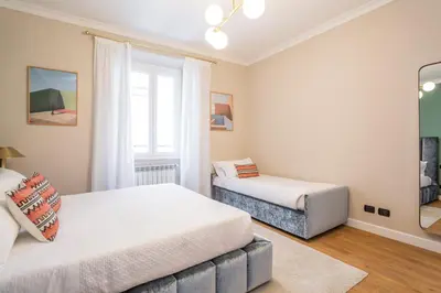 a bedroom with two beds and a window at Daplace - Palazzina Cosima in Rome