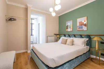 a bedroom with a large bed with a blue headboard at Daplace - Palazzina Cosima in Rome