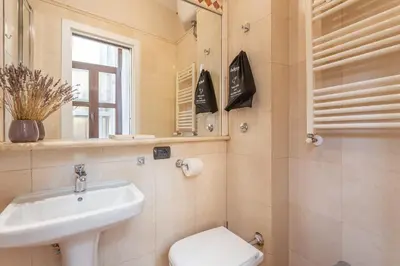 a bathroom with a sink and a toilet and a mirror at Daplace - Palazzina Cosima in Rome