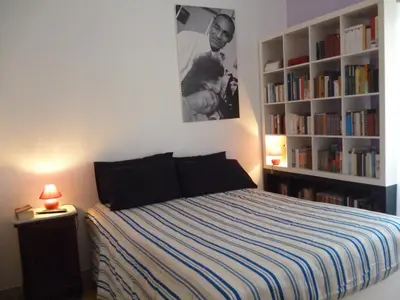 a bedroom with a bed and a book shelf with books at B&B all'ombra del Vaticano in Rome
