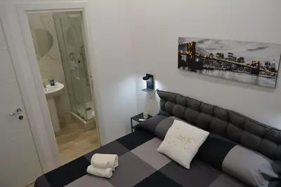 a bedroom with a black and white bed and a bathroom at Casa Amabile in Rome
