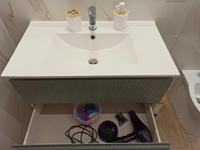 a bathroom vanity with a white sink and some bottles at Casa Amabile in Rome
