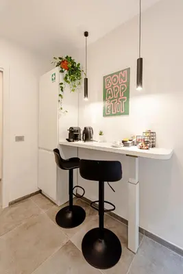 a kitchen with a white counter and two stools at 24VaticanSuite in Rome