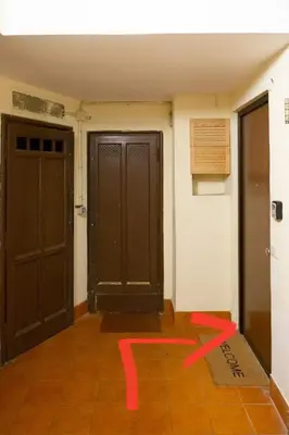 a room with two doors and a red arrow on the floor at Green house in Rome