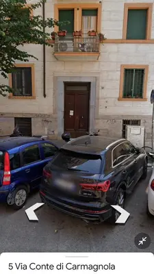 two cars parked in a parking lot in front of a building at Green house in Rome