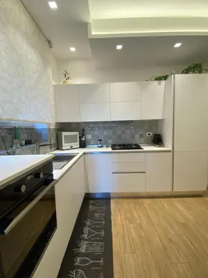 a kitchen with white cabinets and a refrigerator at Appartamento Appio San Giovanni in Rome