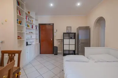 a bedroom with a bed and a kitchen with a refrigerator at Vatican Cozy - Casetta Vaticana in Rome