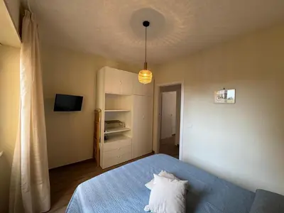 a small bedroom with a blue bed and a light at Apt with balcony in Roman Quiet in Rome