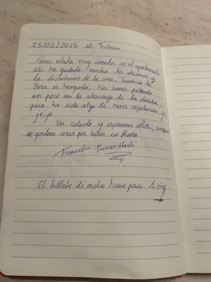 an open notebook with handwriting on the pages at Casa di Alfredo -Appartamento Musei Vaticani in Rome