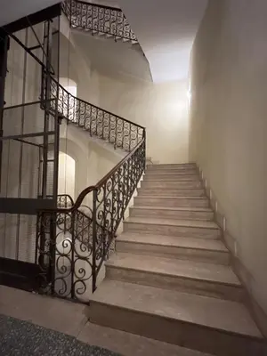 a staircase with a wrought iron rail and concrete steps at Tiburtino Apartment in Rome