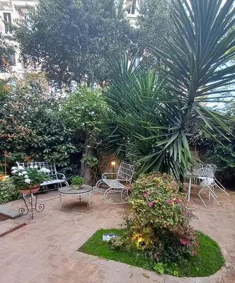 a patio with chairs and tables and plants at Il Giardino del Viaggiatore in Rome