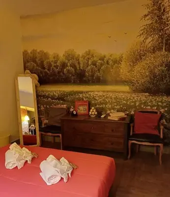 a bedroom with a mirror and a painting on the wall at Il Giardino del Viaggiatore in Rome