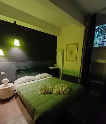 a bedroom with a green bed with two pillows on it at Il Giardino del Viaggiatore in Rome