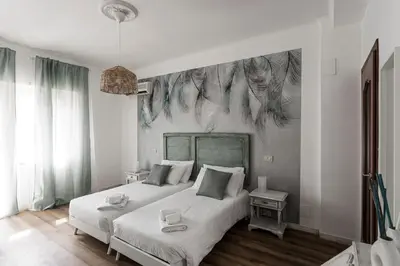 a bedroom with two beds and a chair and a window at Aurelia 386 Vatican House in Rome