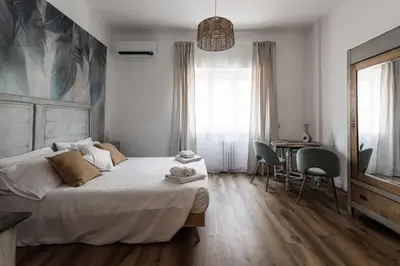 a bedroom with a bed and a table and a mirror at Aurelia 386 Vatican House in Rome