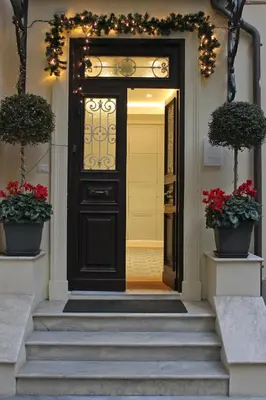 a black front door with flowers and plants in pots at Little Rose Residence in Rome
