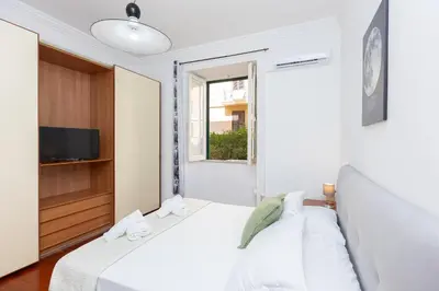 a bedroom with two beds and a tv and a window at Faleria Second by Rental in Rome in Rome