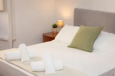 a white bed with three candles on it at Faleria Second by Rental in Rome in Rome