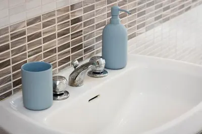 a white sink with a bottle and cups on it at Faleria Second by Rental in Rome in Rome