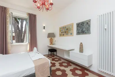 a bedroom with a bed and a desk and a window at Testaccio by Rental in Rome in Rome