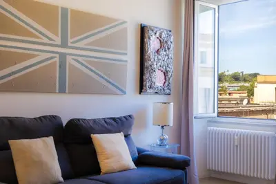 a living room with a blue couch and a window at Testaccio by Rental in Rome in Rome