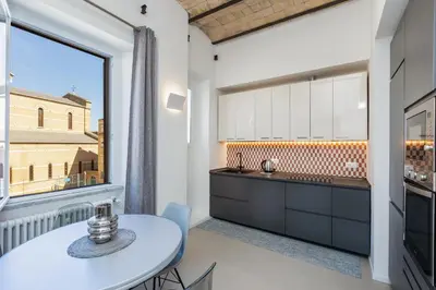 a kitchen with a table and a large window at Testaccio by Rental in Rome in Rome