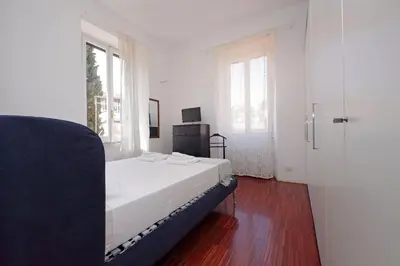 a white bedroom with a bed and a window at 4BNB - Angelo Emo in Rome