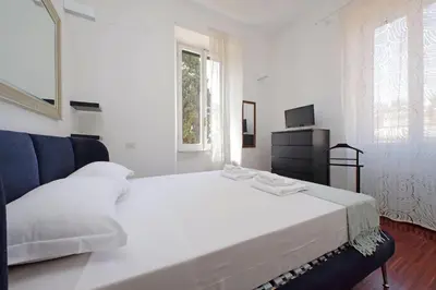 a white bedroom with a large bed and a television at 4BNB - Angelo Emo in Rome