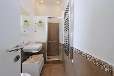 a white bathroom with a sink and a shower at 4BNB - Angelo Emo in Rome