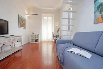 a living room with a blue couch and a tv at 4BNB - Angelo Emo in Rome